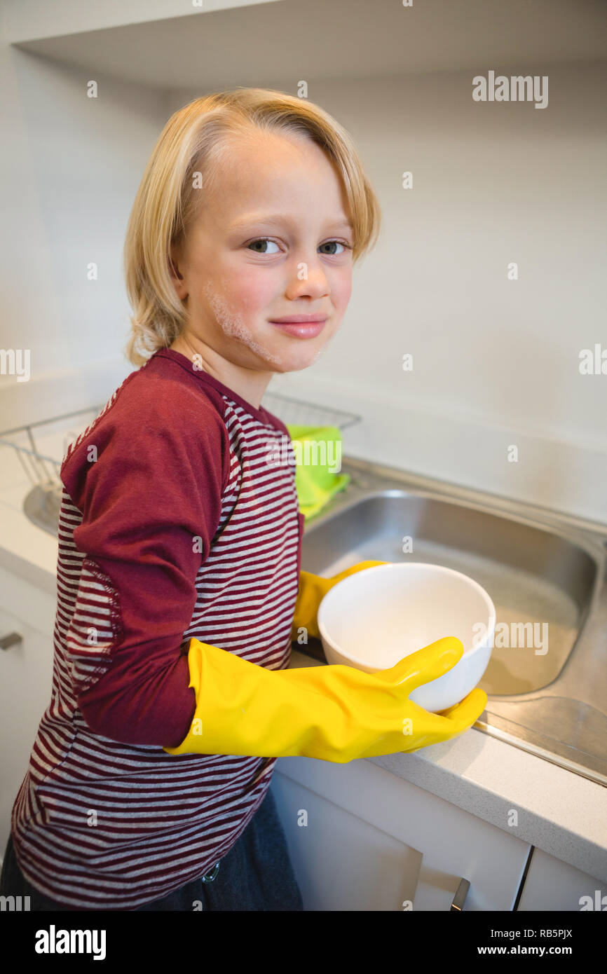 Boy washing utensil in kitchen Stock Photo Alamy
