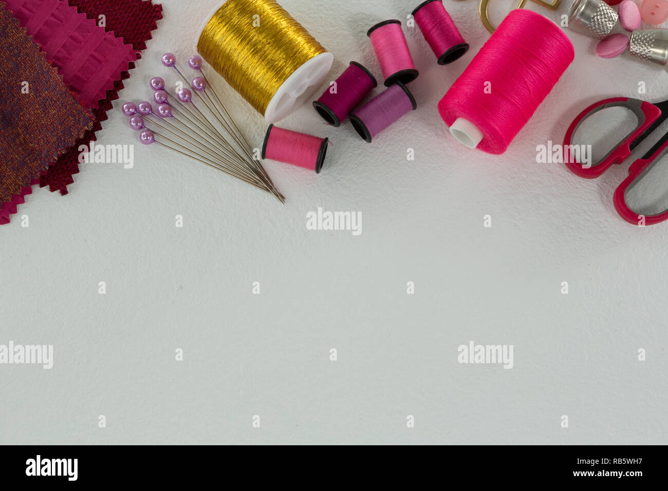 Thread rolls and tools on white background Stock Photo - Alamy