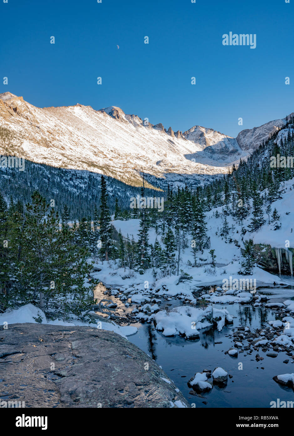 Hiking trail to a frozen lake beneath Spearhead in Rocky Mountain National Park Stock Photo
