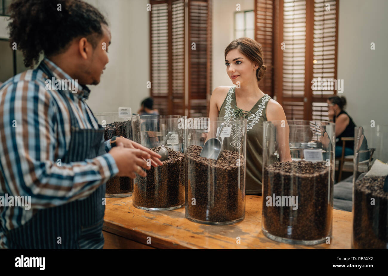 Coffee bean connoisseur sharing information of the types of coffee beans to a potential customer Stock Photo