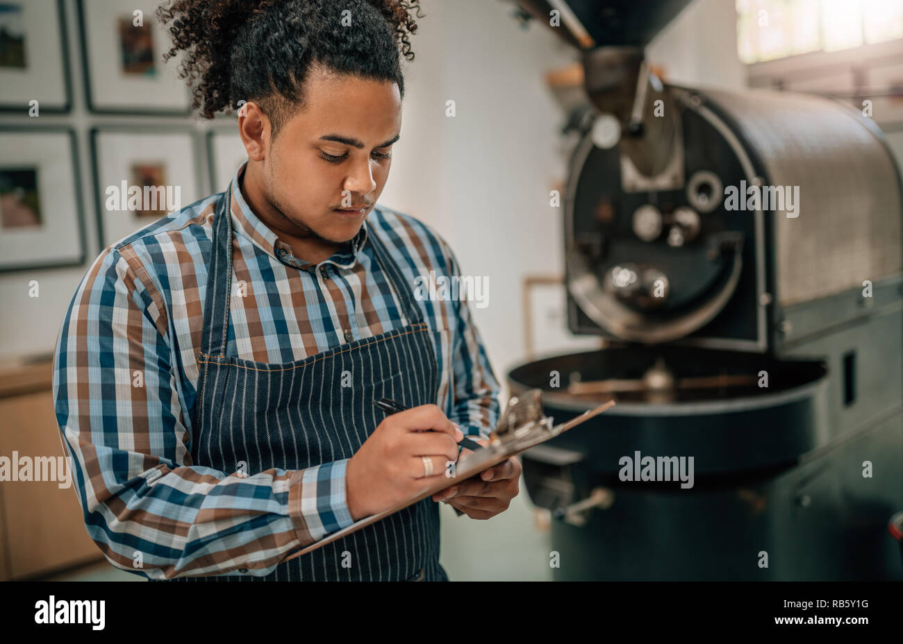 Business owner of a coffee roastery checking a quality control list Stock Photo