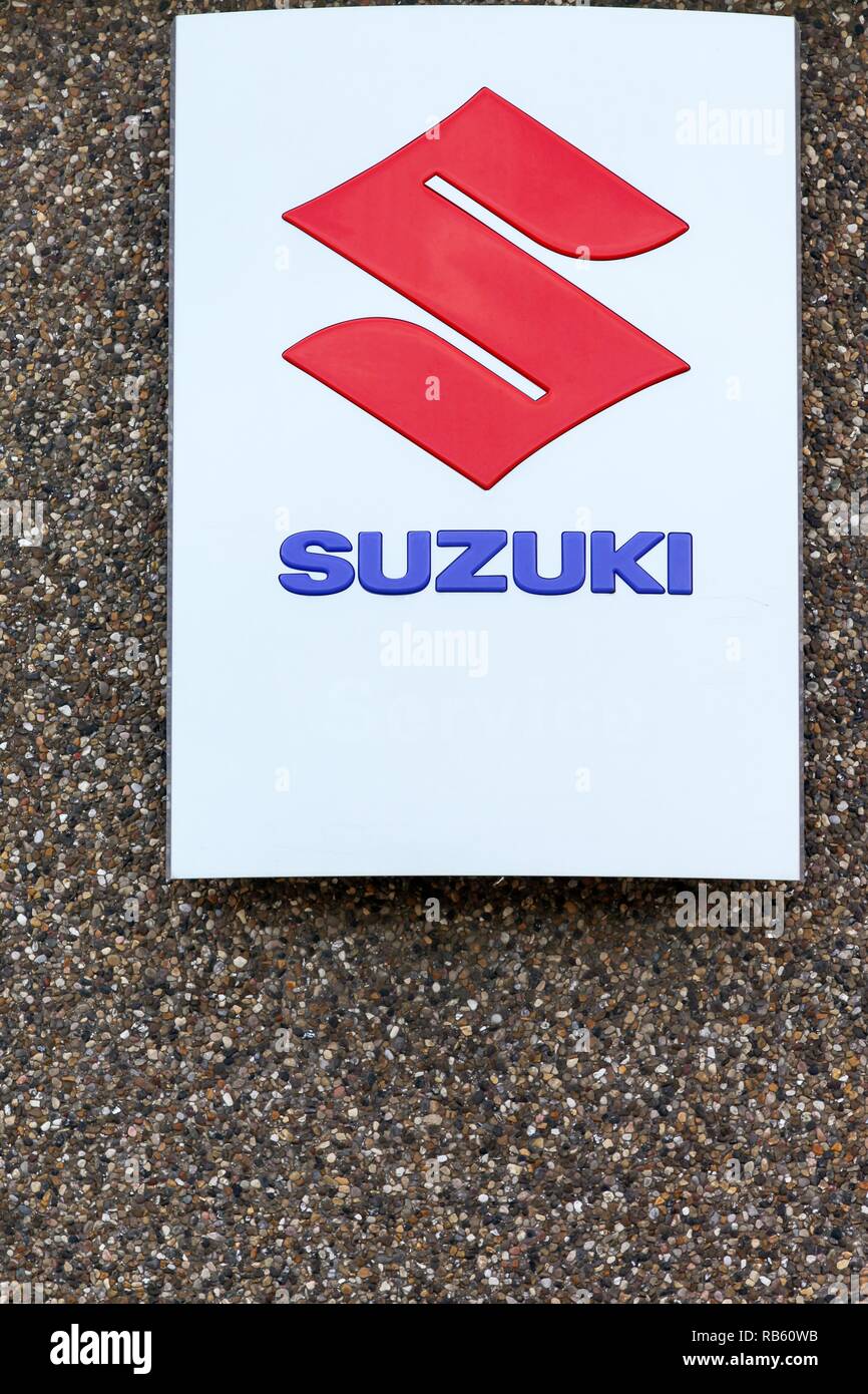 Skanderborg, Denmark - September 6, 2015: Suzuki logo on a wall. Suzuki is a Japanese multinational which specializes in manufacturing automobile Stock Photo