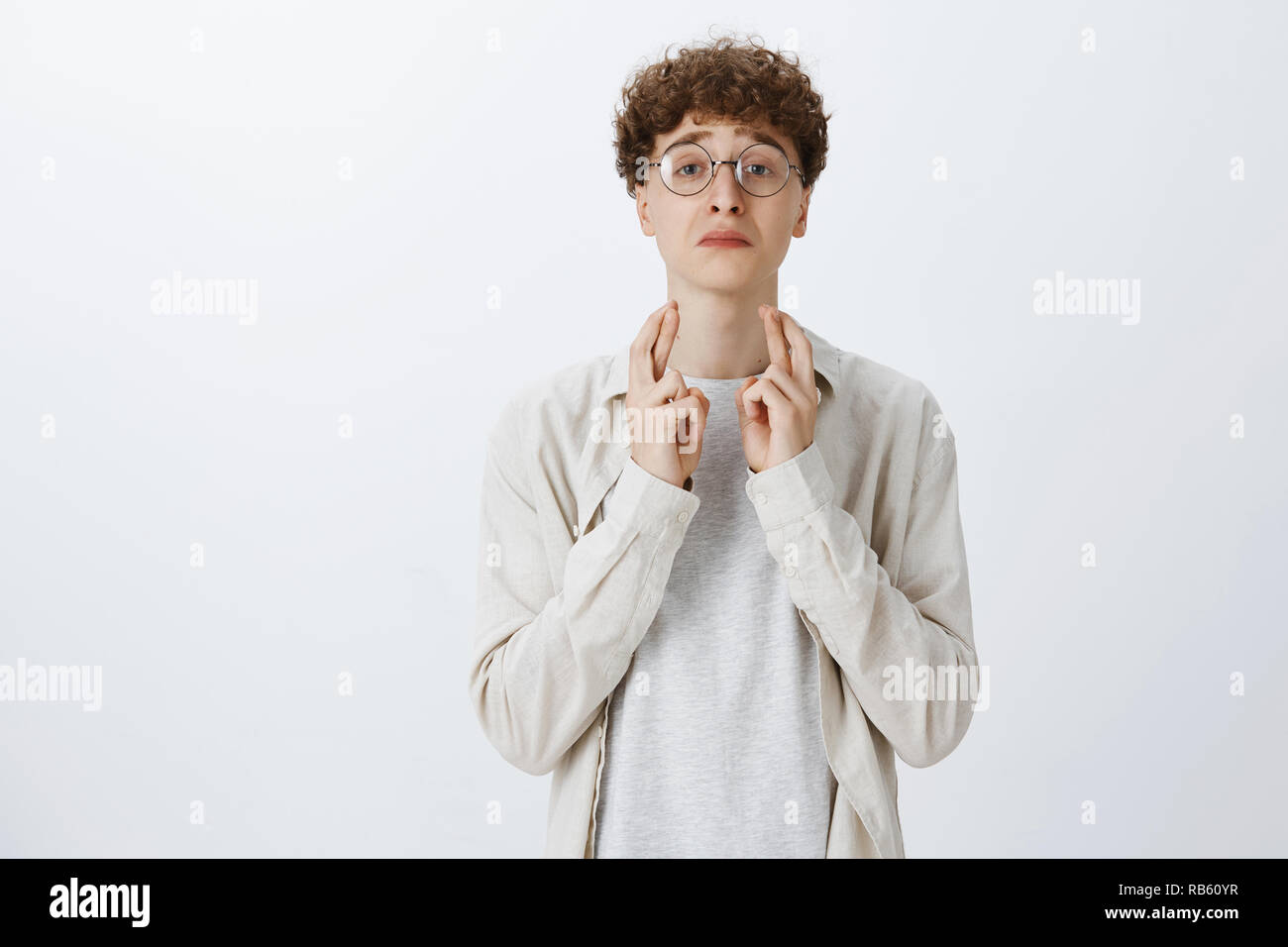 Upset Silly Thin Young Boy With Curly Hairstyle In Round Glasses
