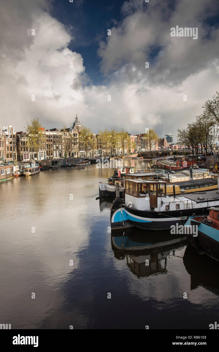 The Netherlands, Amsterdam, View on canal houses and houseboats in canal called Binnenkant. Approaching hail storm. Stock Photo