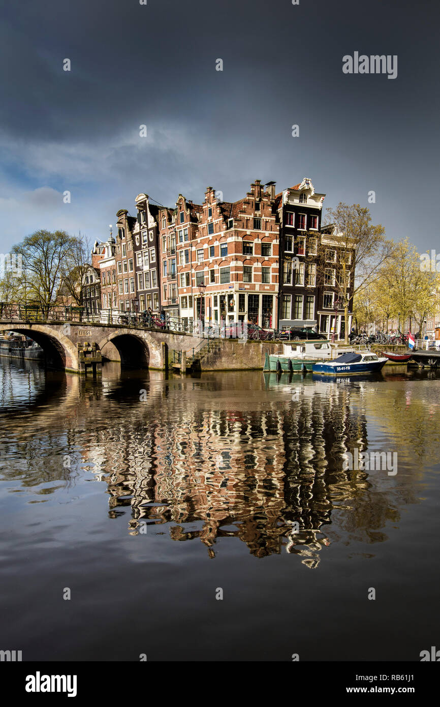 The Netherlands, Amsterdam, Canal houses and houseboats in canal called Brouwersgracht. Unesco, world heritage site. Approaching hail storm. Stock Photo