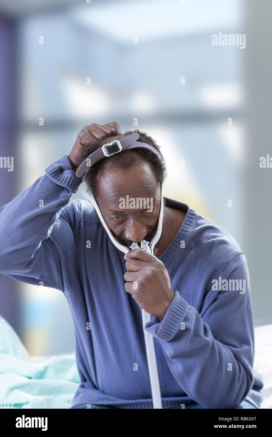 Man using a CPAP (Continuous Positive Airway Pressure) mask to treat