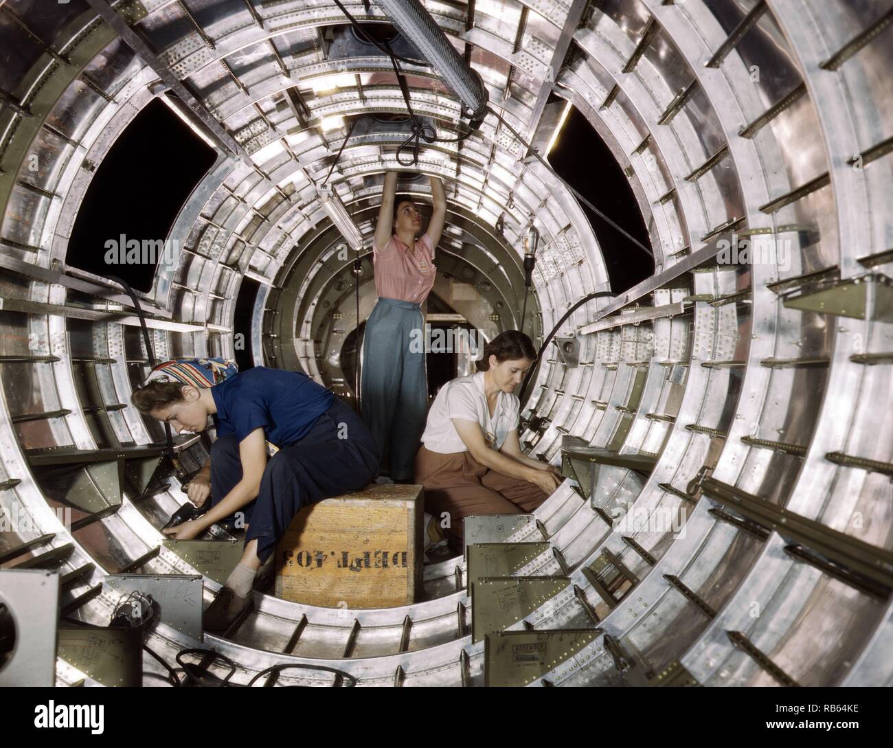 Photograph of female workers installing fixtures and assemblies to a tail fuselage section of a B-17F bomber at the Douglas Aircraft Company, Long Beach, Calif. Better known as the 'Flying Fortress,' the B-17F is a later model of the B-17 which distinguished itself in action in the South Pacific, over Germany and elsewhere. It is a long range, high altitude heavy bomber, with a crew of seven to nine men, and with armament sufficient to defend itself on daylight missions. Dated 1942 Stock Photo