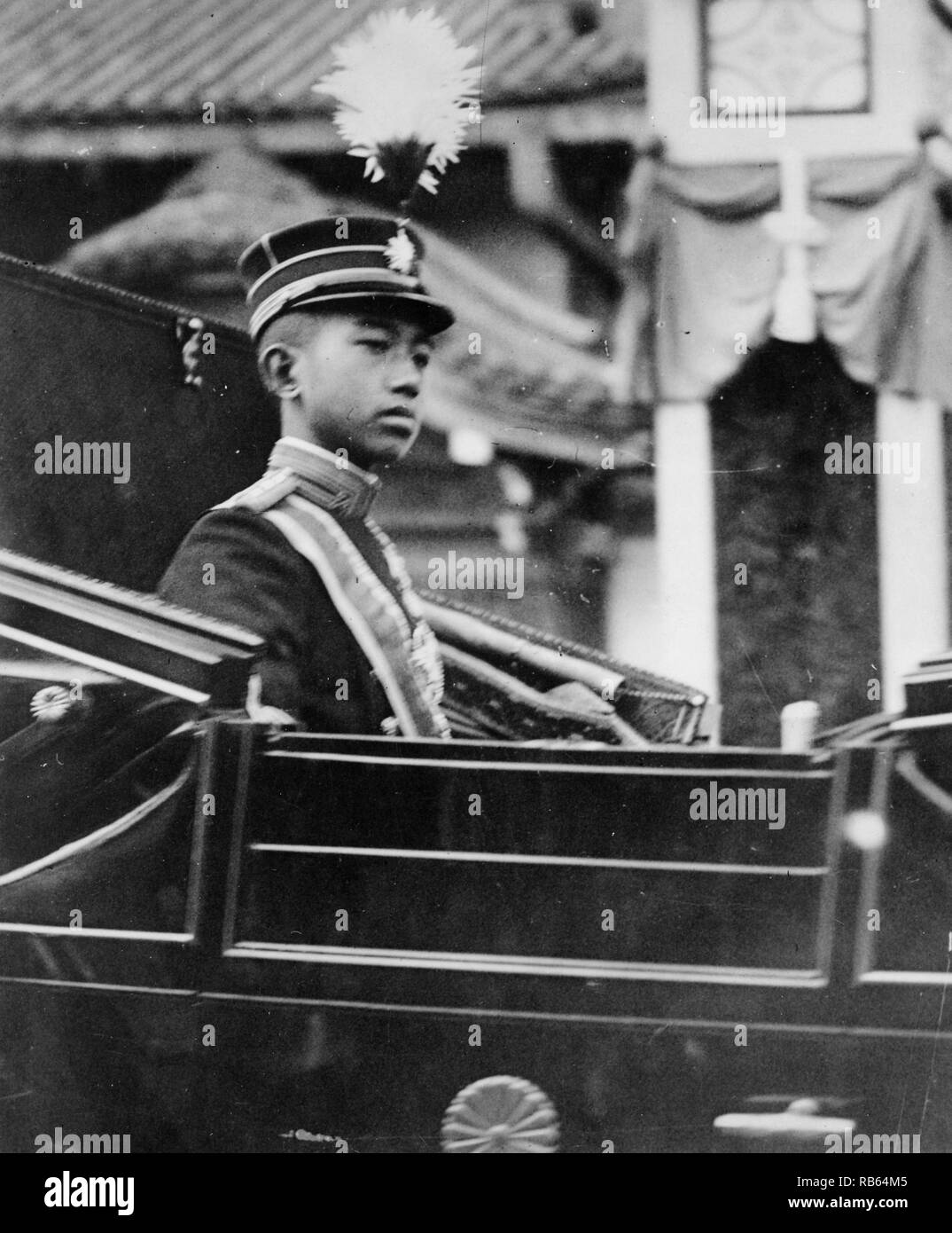 Photograph of Hirohito, Emperor of Japan, half-length portrait, facing right, seated in carriage with chrysanthemum emblem on the door. Dated 1918 Stock Photo