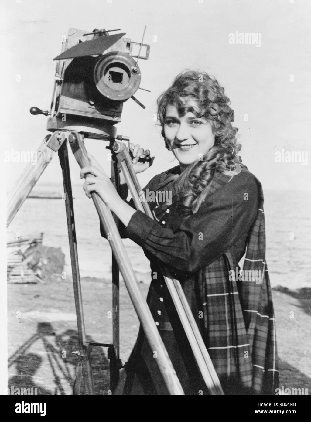 Photograph of the Silent film era actress Mary Pickford (1892 - 1979) posing with Film Camera. Dated 1876 Stock Photo