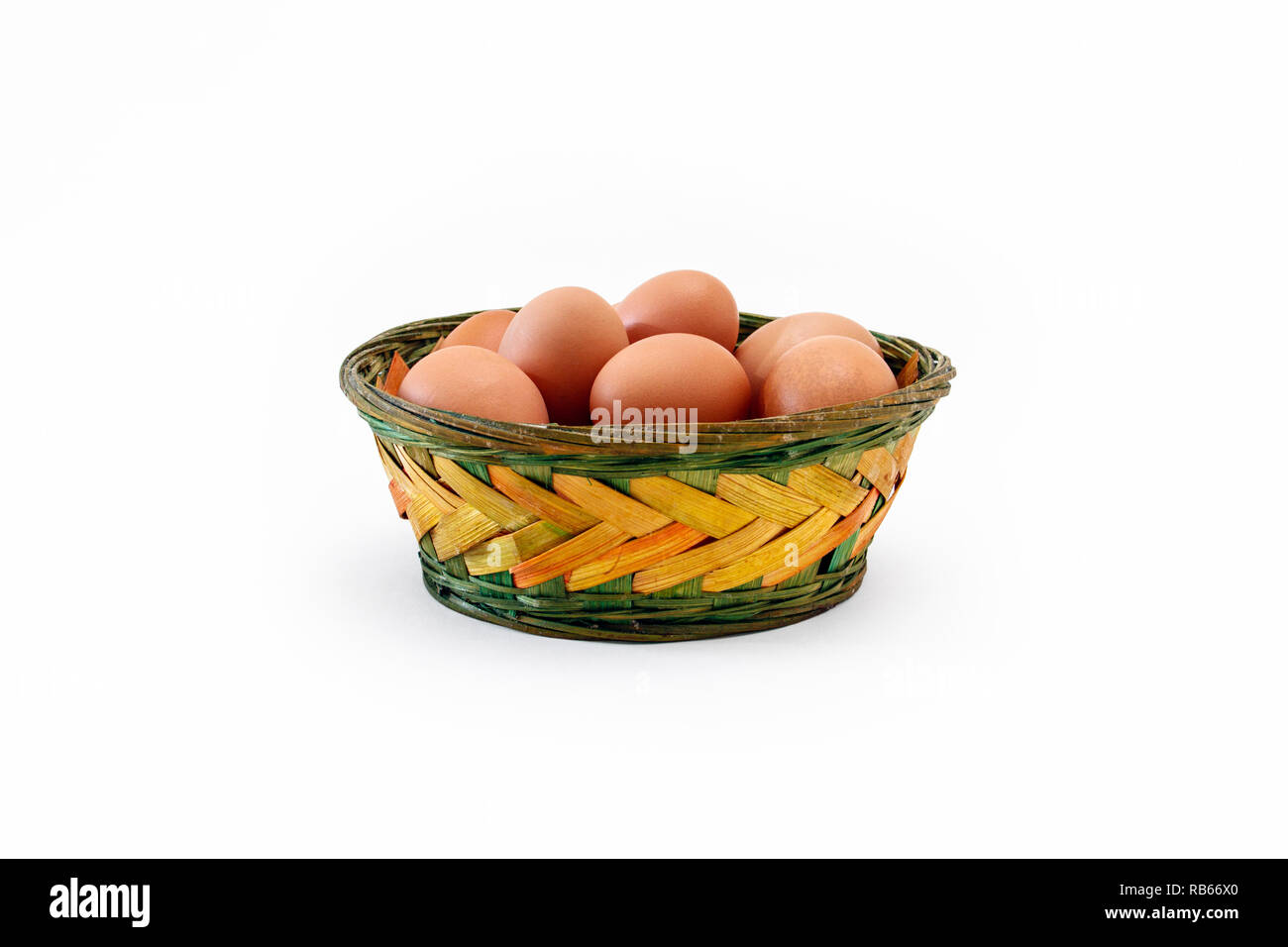 Large brown free-range eggs in a coloured rustic wicker basket Stock Photo