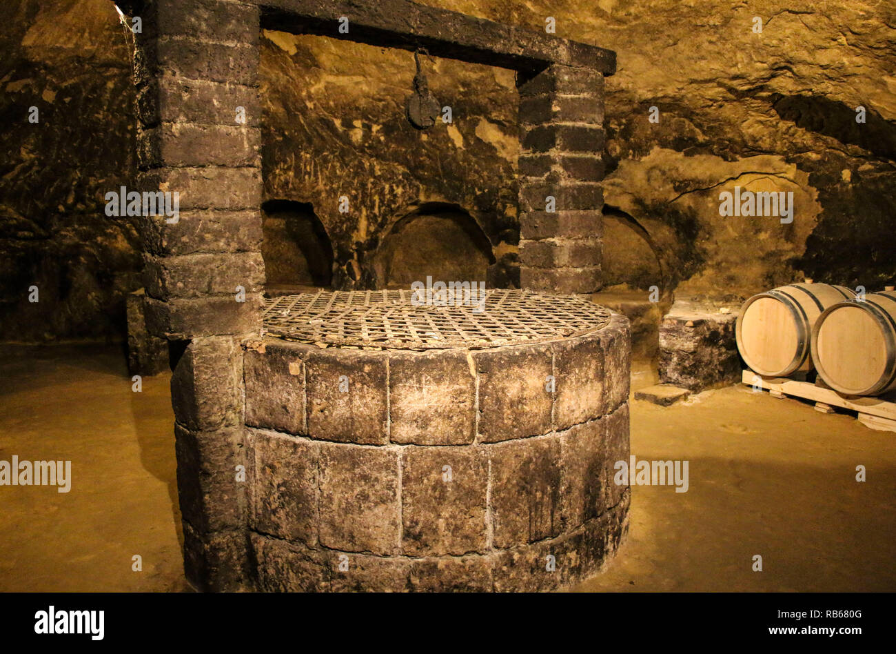 Old wine cellar with barrels of wine and an old well Stock Photo Alamy
