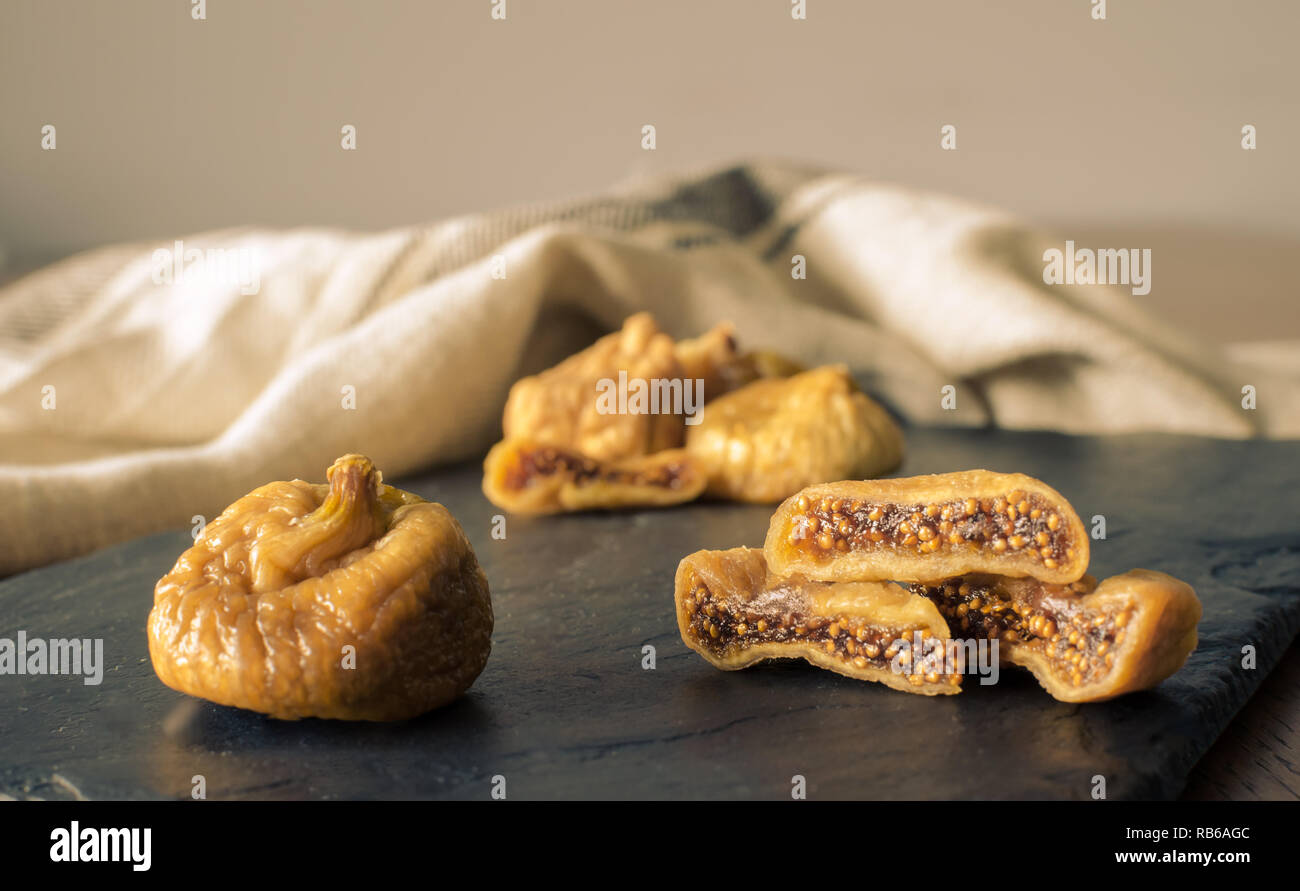 Dried figs with sliced one on dark rustic background Stock Photo