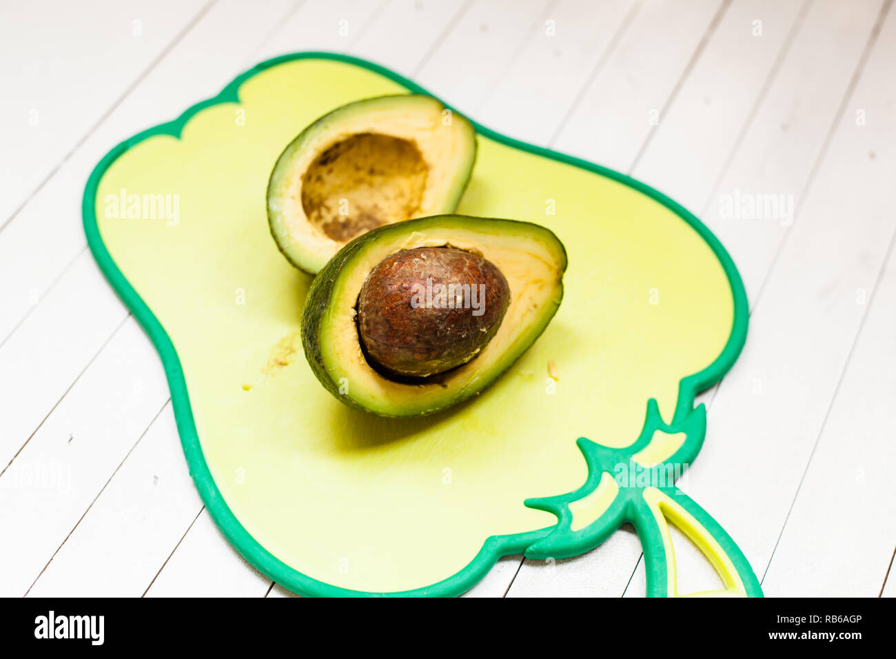 Fresh avocado on cutting board over wooden background Stock Photo - Alamy