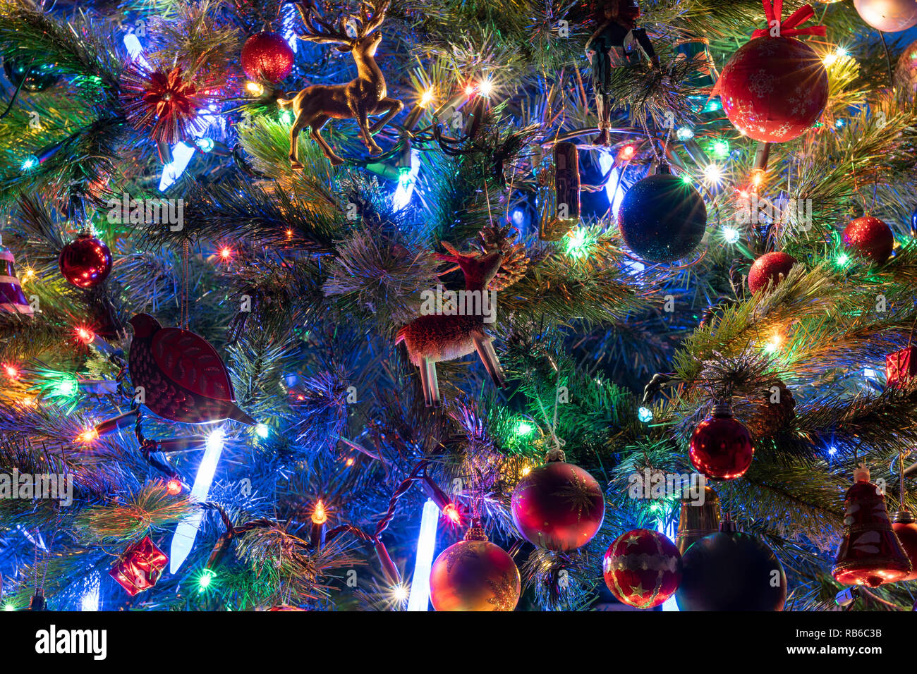 A closeup of decorations and fairy lights on a Christmas tree in