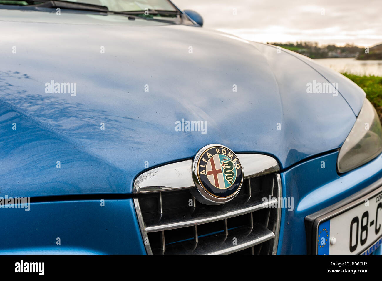 Alfa Romeo Badge on the front of a blue 1.6 16v 147. Stock Photo