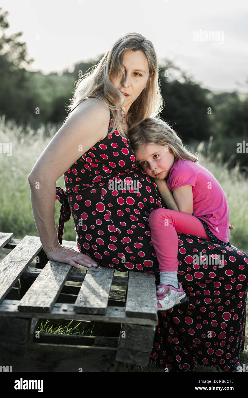 Crying Girl Looking For Comfort Nestled On Her Pregnant Mother S