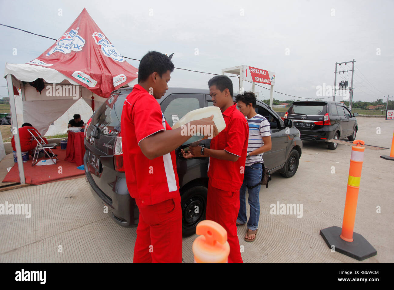A vehicle seen being refilled manually at the rest area of ??Ngawi, East Java. Stock Photo