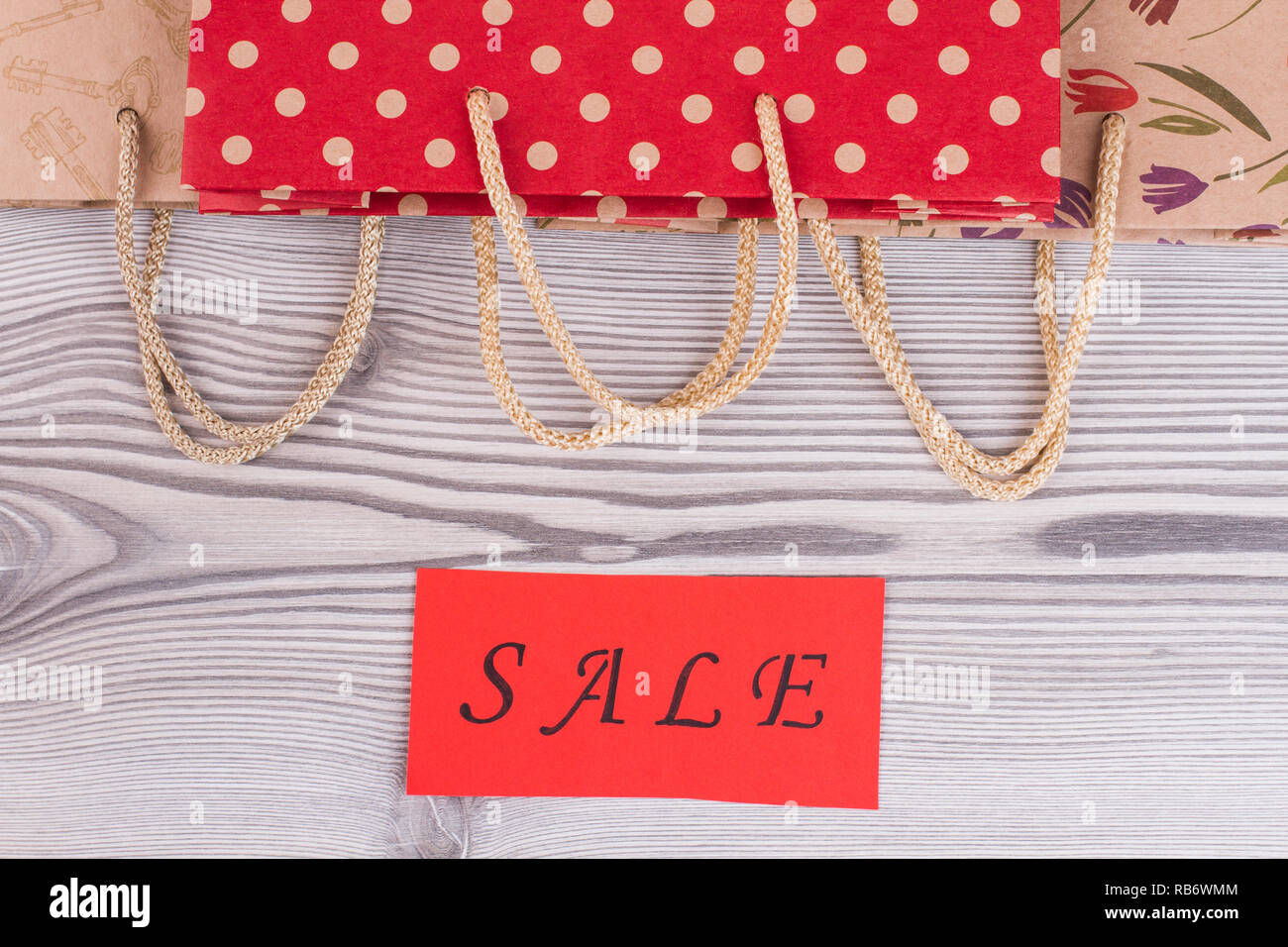 Download Paper Shopping Bags With Rope Handles Paper Bags And Red Card With Inscription Sale On Wooden Background Stock Photo Alamy