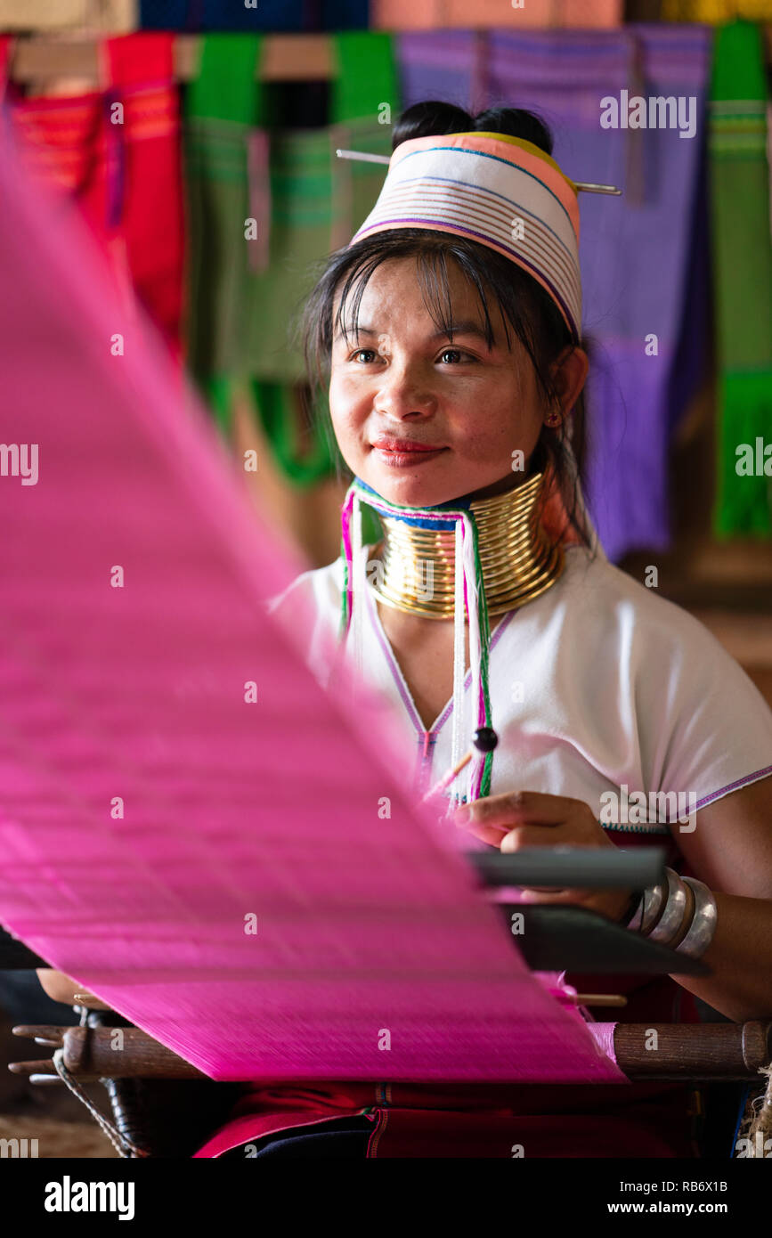 Girl from the Kayan tribe sewing silk in Inle Lake, Myanmar Stock Photo