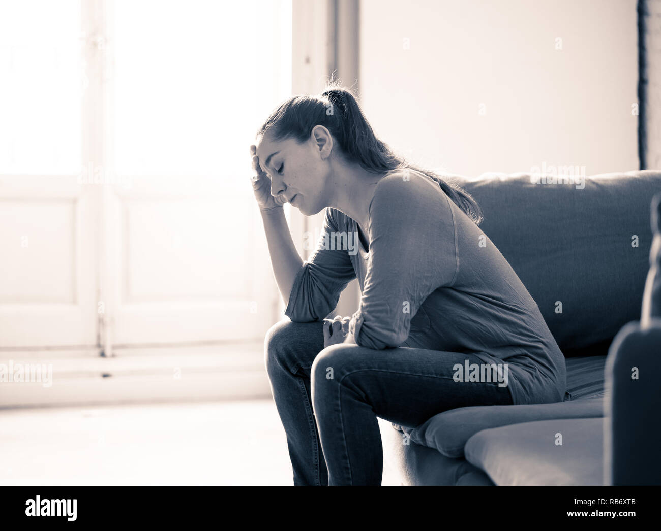 Young attractive latin woman lying at home living room couch feeling sad tired and worried suffering Depression in Mental health, Problems Emotional p Stock Photo