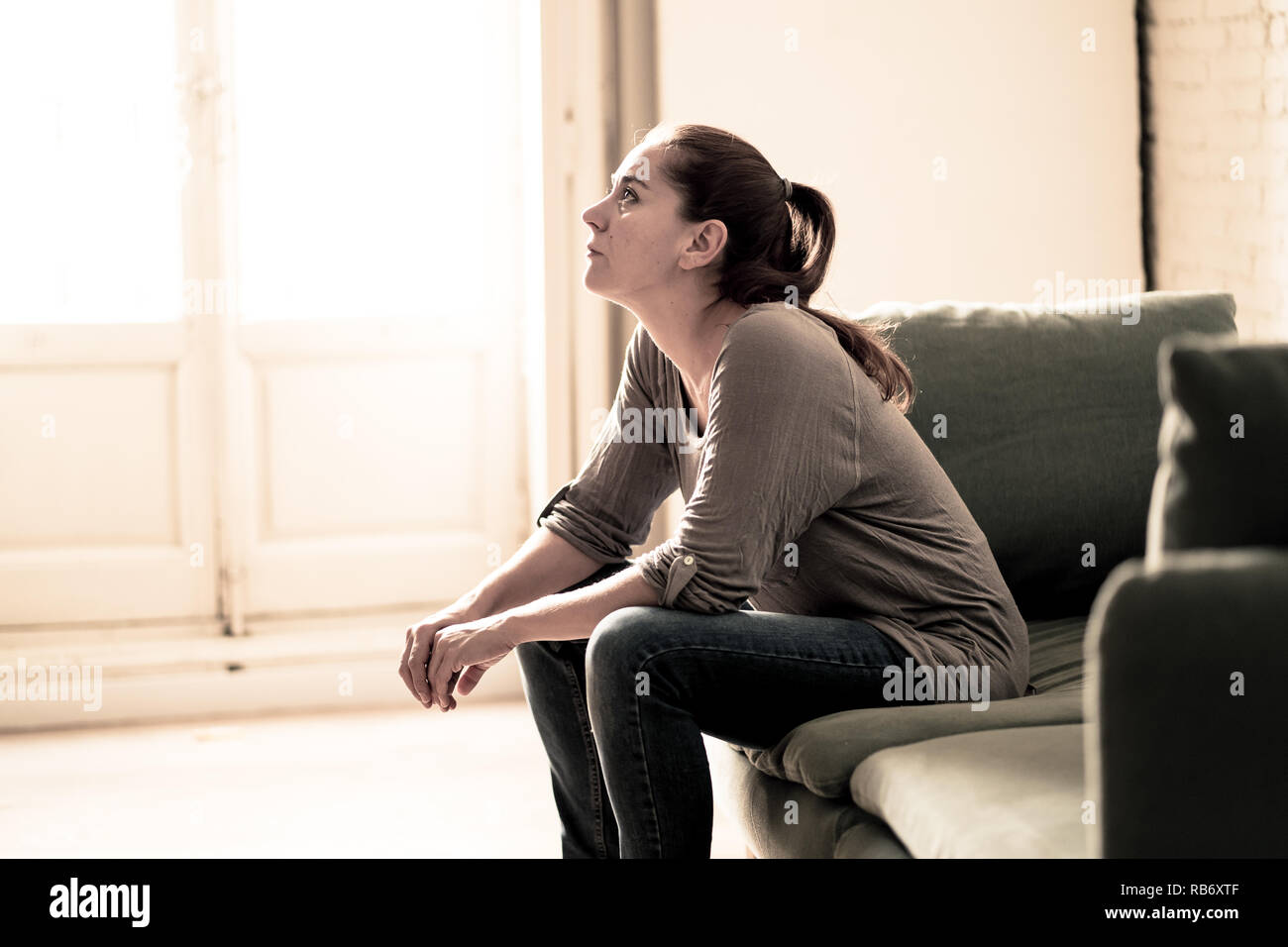 Young attractive latin woman lying at home living room couch feeling sad tired and worried suffering Depression in Mental health, Problems Emotional p Stock Photo