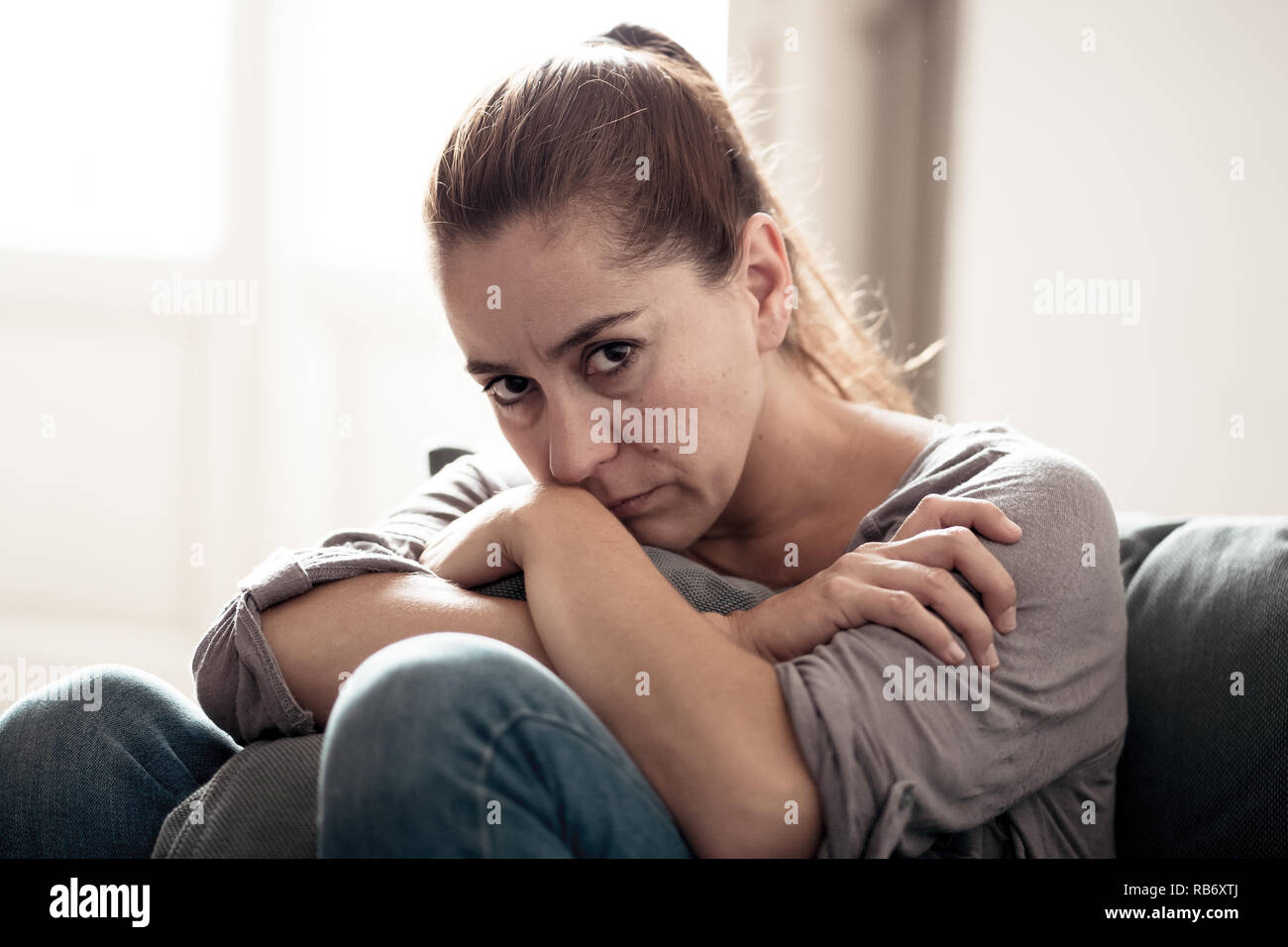 Young attractive latin woman lying at home living room couch feeling sad tired and worried suffering Depression in Mental health, Problems Emotional p Stock Photo