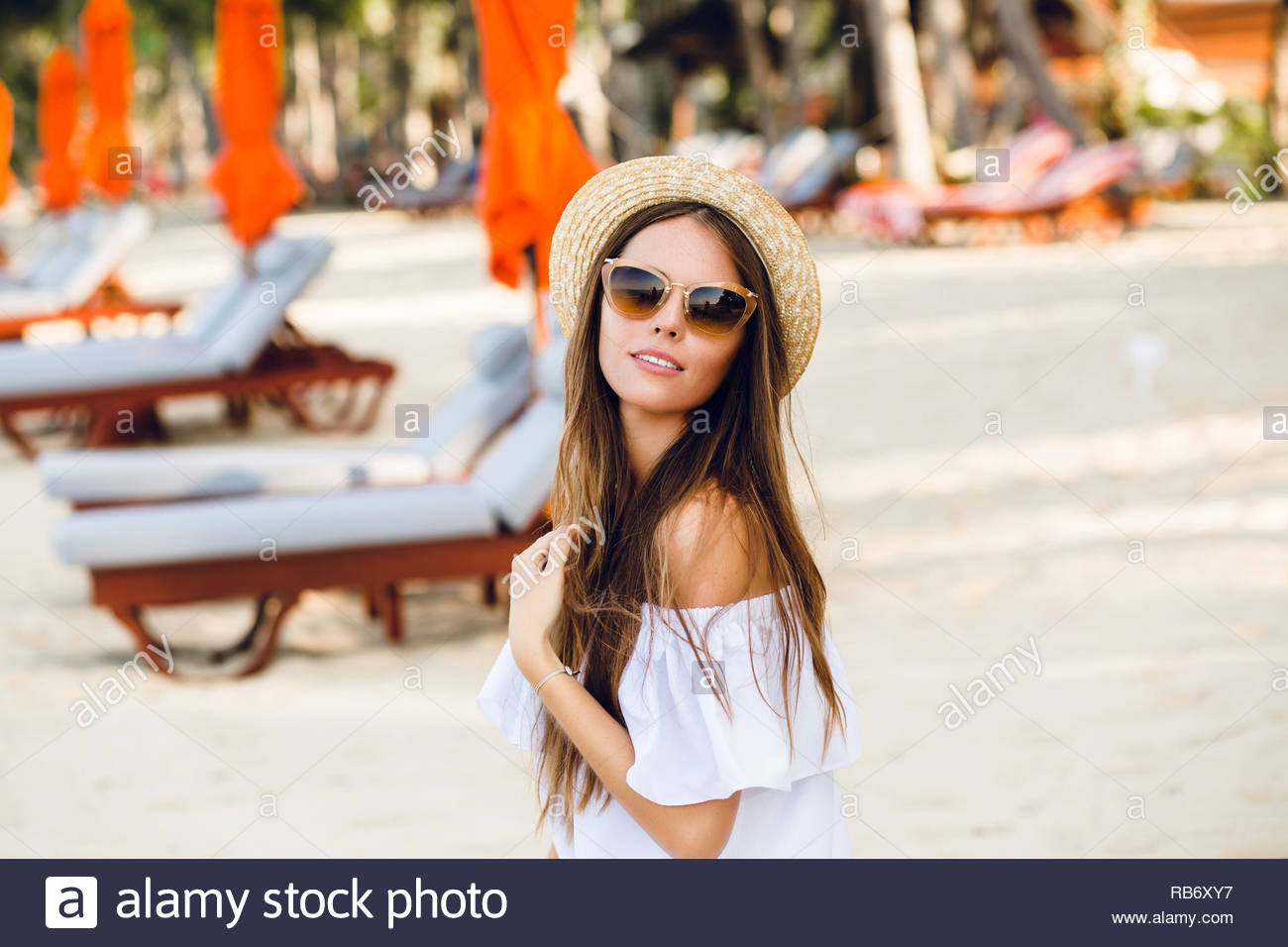 Cute Girl In Brown Sunglasses And Straw Hat Smiles Charmingly She