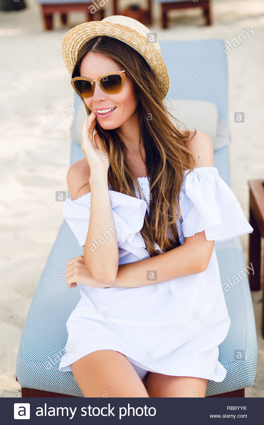 Cute Girl In Brown Sunglasses And Straw Hat Smiles Widely And