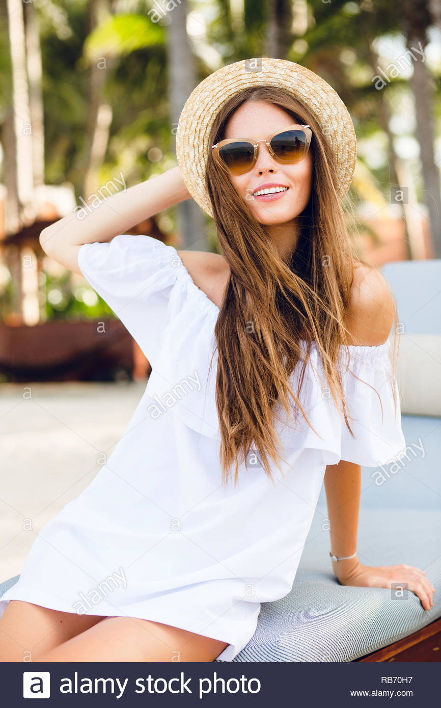 Cute Girl In Brown Sunglasses And Straw Hat Smiles Charmingly She