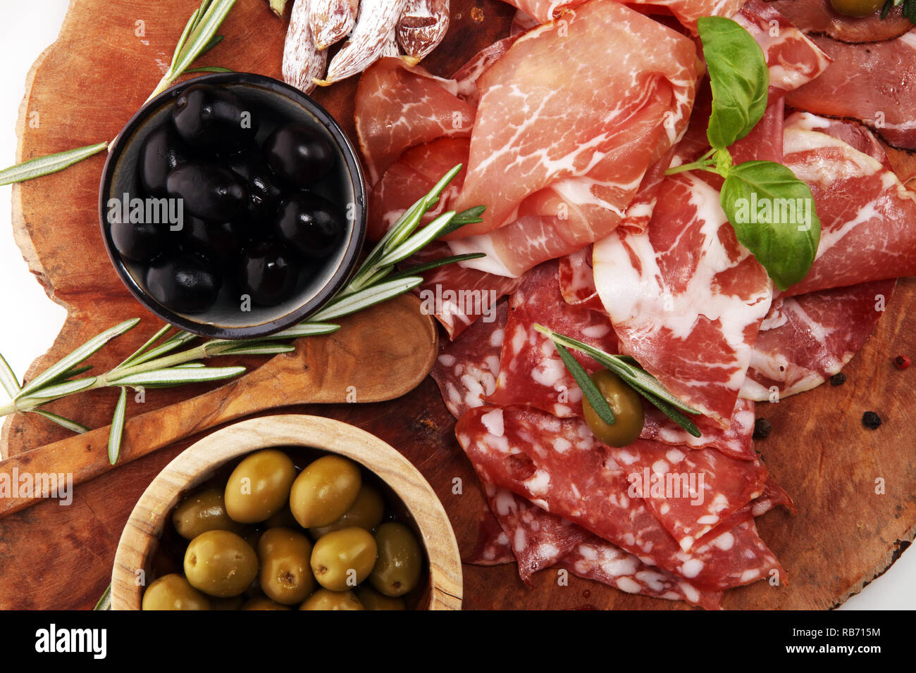 Marble cutting board with prosciutto, bacon, salami and sausages on