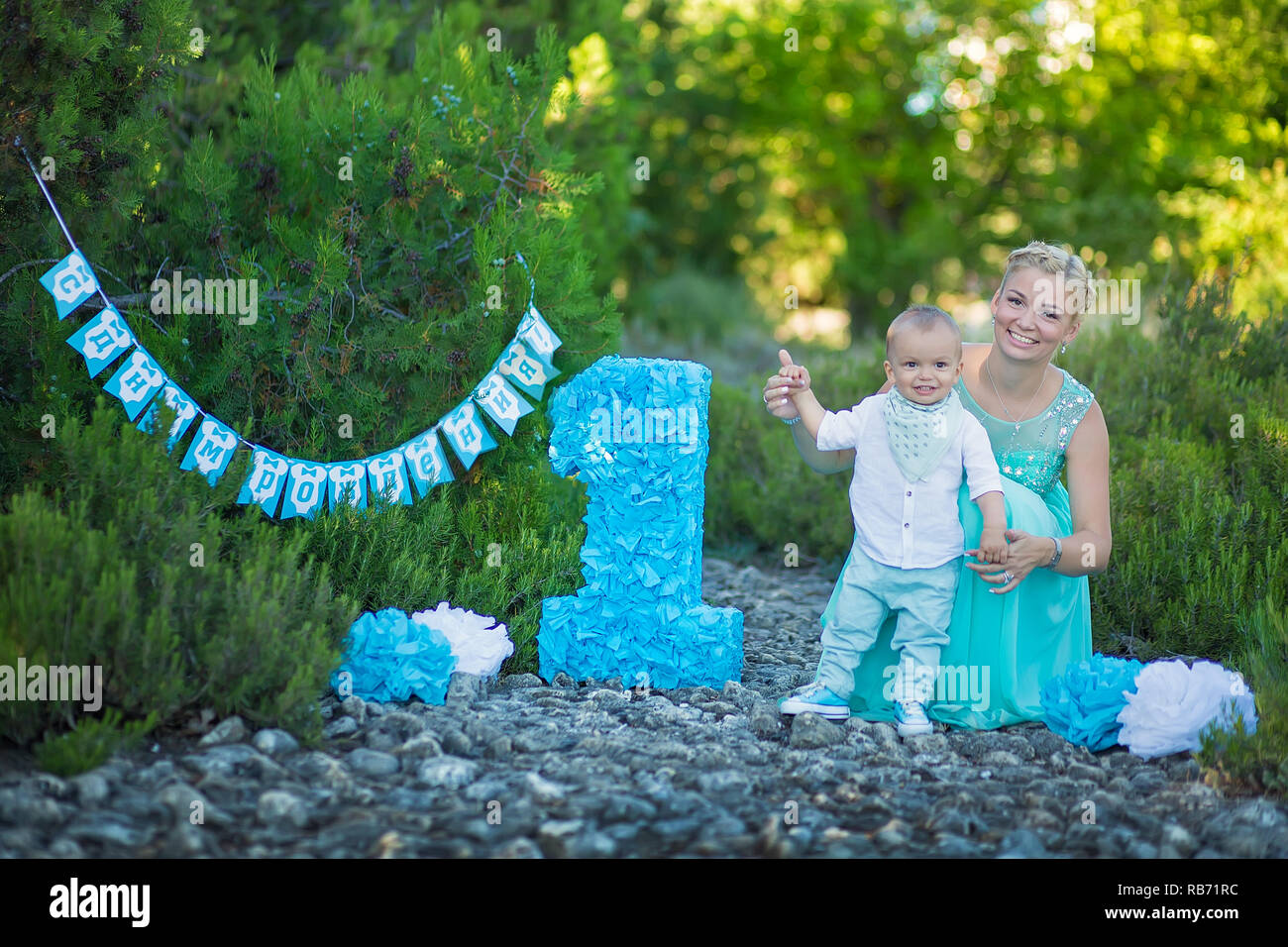 Beautifull mother lady mom in stylish blue dress together with her son and number one birthday in park Stock Photo Alamy