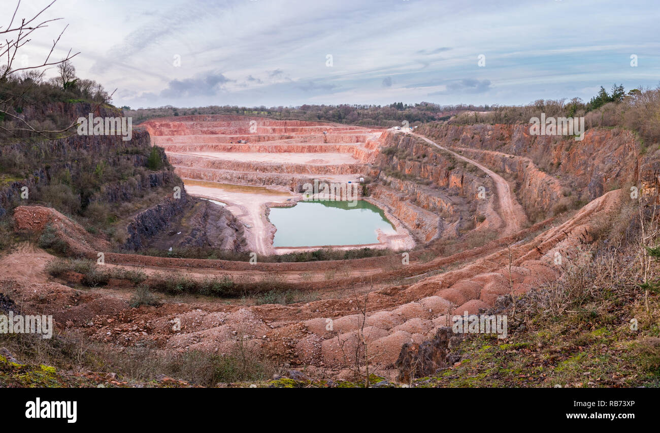 Wide angle view of Stoneycombe Quarry in Devon, England, UK. Limestone is quarried from the site and a lake has formed at the bottom Stock Photo