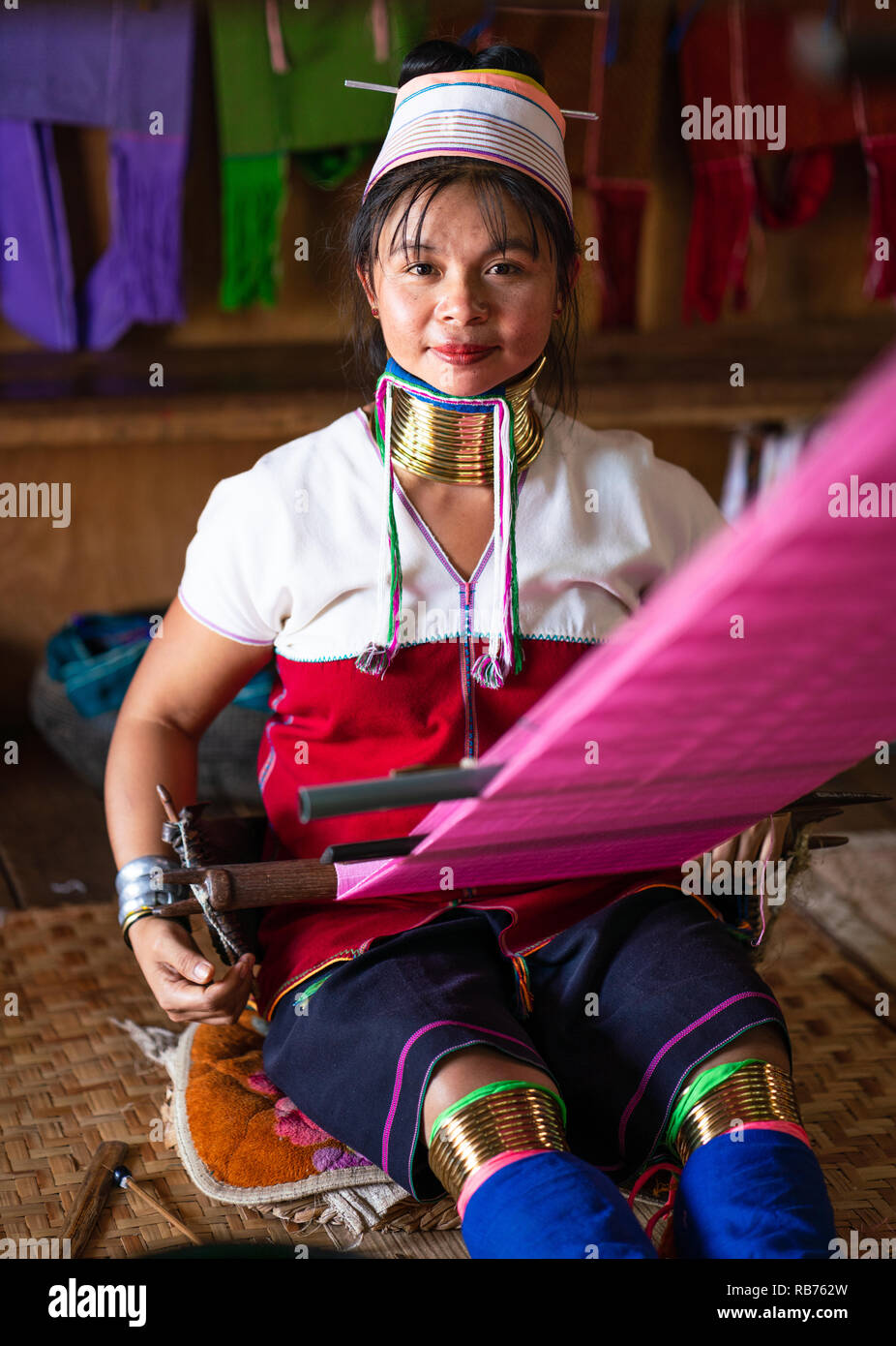 Girl from the Kayan tribe sewing silk in Inle Lake, Myanmar Stock Photo