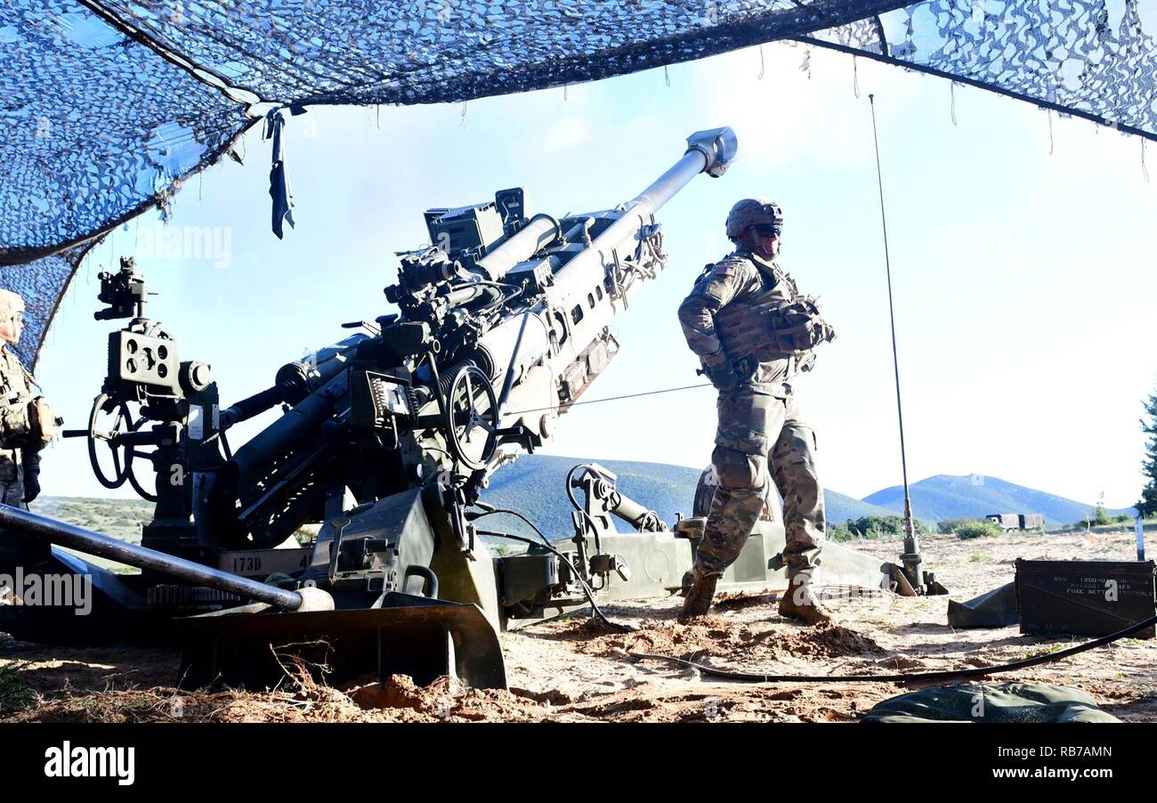 A U.S. Army artilleryman, assigned to Battery C, 4th Battalion, 319th Airborne Field Artillery Regiment, 173rd Airborne Brigade, pulls a lanyard on an M777 Howitzer, activating the trigger mechanism during live fire training as part of exercise Summer Tempest 16 at Capo Teulada in Sardinia, Italy, Dec. 1, 2016. Summer Tempest 16 is a multinational exercise designed to improve and build upon a shared understanding of live fire operations, using weapons systems and tactical procedures. Stock Photo