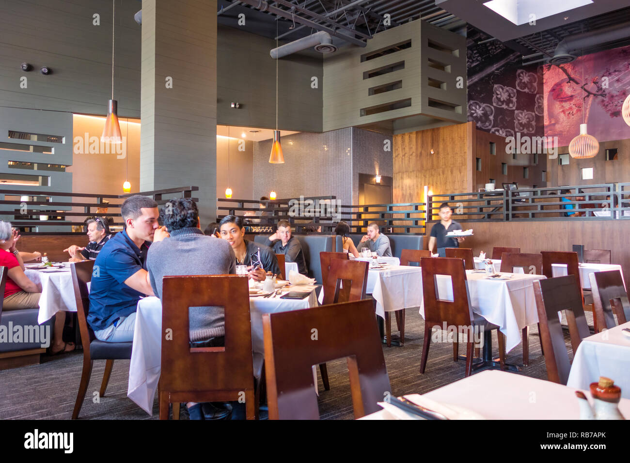 Interior of the Spoon & Fork Japanese-Thai restaurant in Toronto with people sitting and enjoying food. Stock Photo