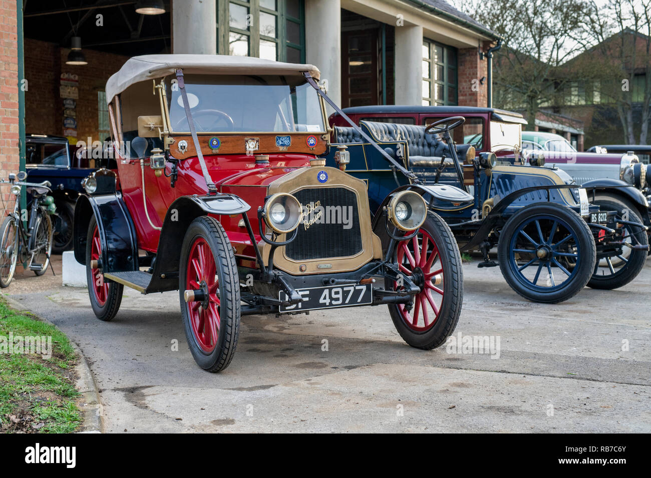 Line of Vintage cars outside a garage at Bicester Heritage centre. Bicester, Oxfordshire, England Stock Photo