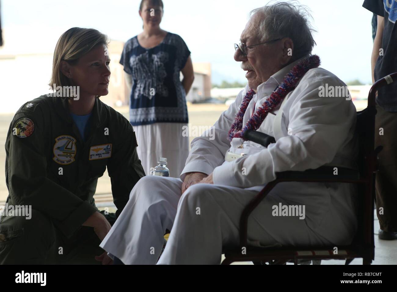 Melvin Heckman, a Pearl Harbor survivor, speaks with Cmdr. Beth Regoli, the commanding officer of Patrol Squadron 9, about his experiences during the attack on Pearl Harbor at Hangar 104 aboard Marine Corps Base Hawaii, December 2, 2016. Heckman is known for rescuing sailors from the USS Arizona during the attack on Pearl Harbor after the ship was attacked by Japanese Zeros. 'I reached out to grab a man's hand to help him up and take him to the island,' said Heckman, a Sheridan, Wyoming, native. 'I got him out of the water and saw that everything below his belly button was missing; he died in  Stock Photo