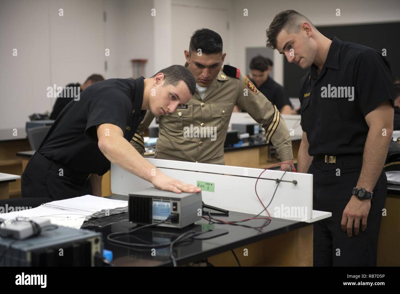 ANNAPOLIS, Md. (Dec. 2, 2016)  United States Naval Academy (USNA) Midshipman 3rd Class Cody Mendelow, Midshipman 3rd Class Gavin O’Donnell and Mexican Cadet Ricardo Fuentes work together to solve a physics equation. Cadets from Mexico's Military Academy, Heroico Colegio Militar, are visiting USNA to play an exhibition American-style football game with the USNA Sprint Football team. Stock Photo