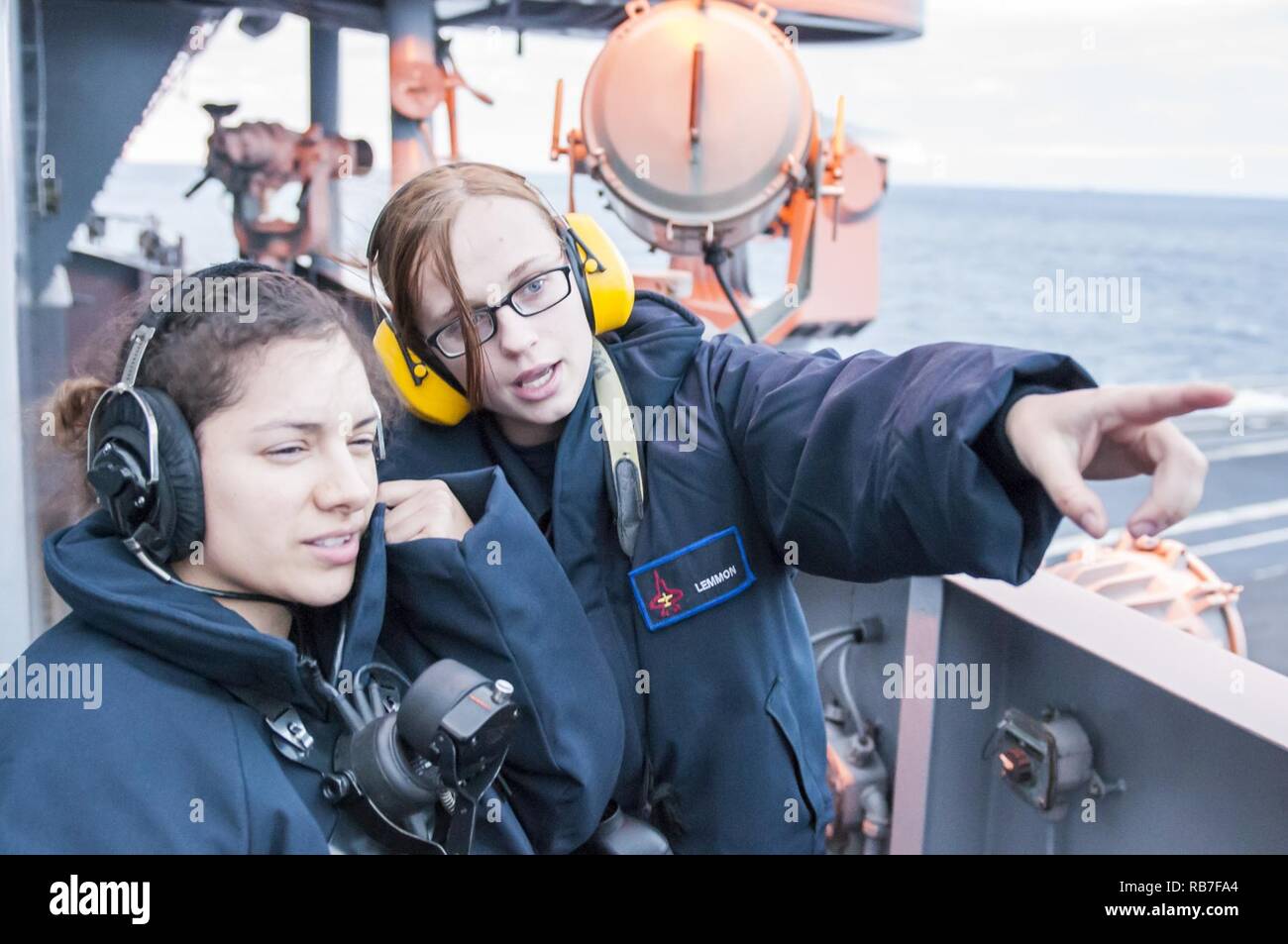 ATLANTIC OCEAN (Dec. 3, 2016) Seaman Caitlin Lemmon trains Seaman Quirina Zayas on how to point out contacts during forward lookout watch aboard the aircraft carrier USS George H.W. Bush (CVN 77). GHWB is underway conducting a Composite Training Unit Exercise (COMPTUEX) with the George H.W. Bush Carrier Strike Group in preparation for an upcoming deployment. Stock Photo