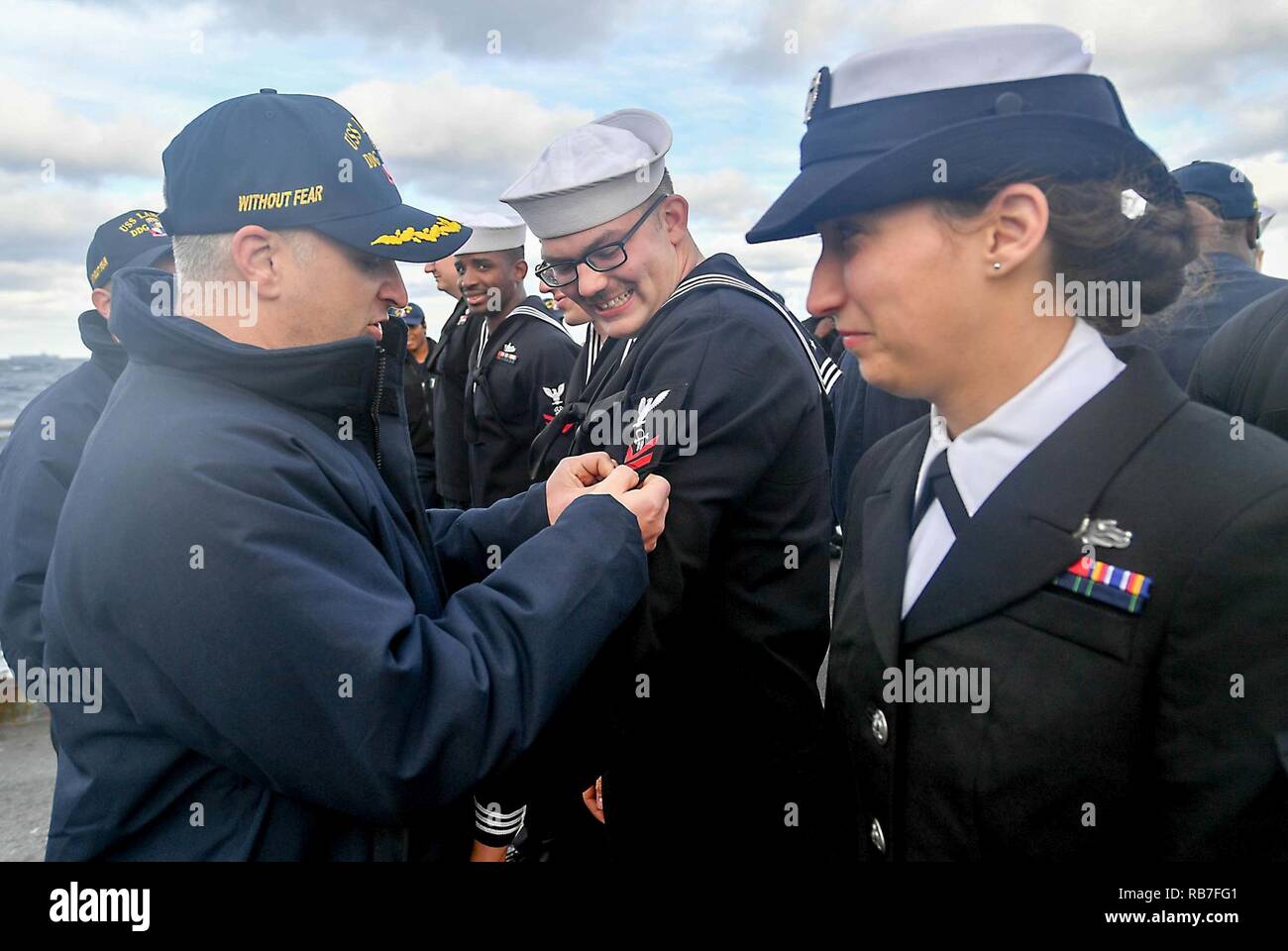 ATLANTIC OCEAN (Dec. 3, 2016) Cmdr. Jason Labott, commanding officer, left, tacks a stitch on Petty Officer 2nd Class Frank Maurin's dress blue uniform during a frocking ceremony aboard the guided-missile destroyer USS Laboon (DDG 58). Laboon is currently underway conducting a Composite Training Unit Exercise (COMPTUEX) with the George H. W. Bush Carrier Strike Group in preparation for an upcoming deployment. Stock Photo