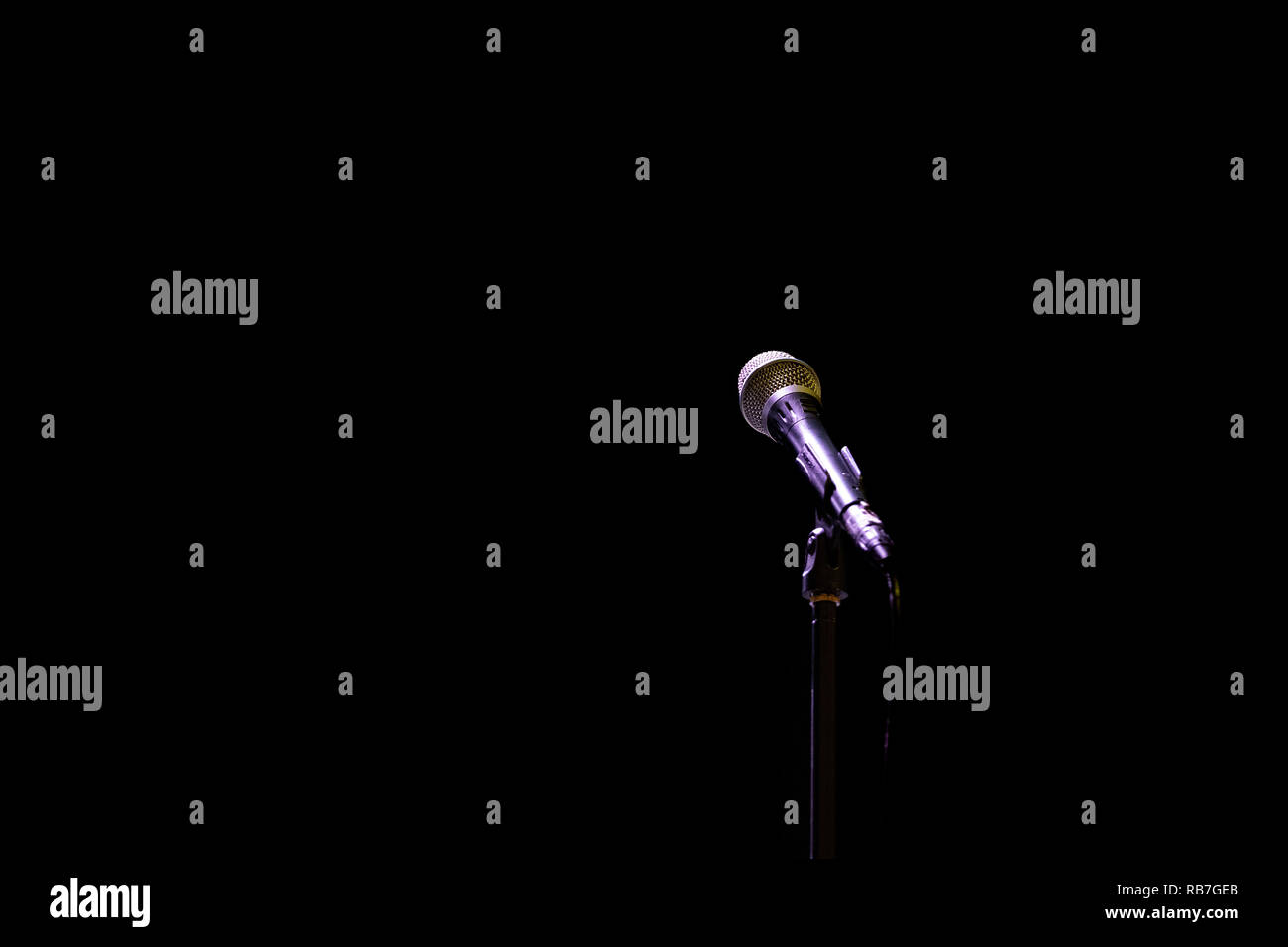 Microphone on a stand on an empty stage Stock Photo