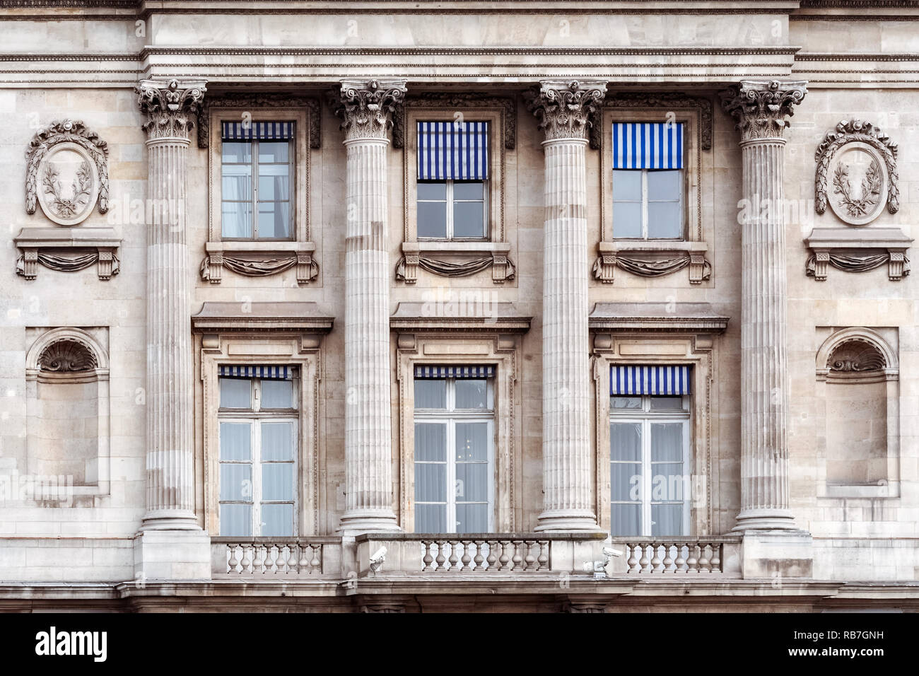 Rectangular windows with columns, a balcony and niches against a marble ...