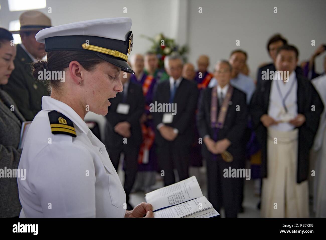 PEARL HARBOR (Dec. 6, 2016) Lt. Emily Rosenzweig, a chaplain assigned to 3rd Radio Battalion Religious Ministry Team at Marine Corps Base Hawaii, reads a Hebrew prayer aboard the USS Arizona Memorial during an Interfaith Prayer service and Floral Tribute. The event allowed religious leaders from the U.S. military, Hawaii, and Japan to engage in prayer to honor the fallen service members. Dec. 7, 2016, marks the 75th anniversary of the attacks on Pearl Harbor and Oahu. Since Dec. 7, 1941, the U.S. and Japan have endured more than 70 years of continued peace, a cornerstone of security and prospe Stock Photo