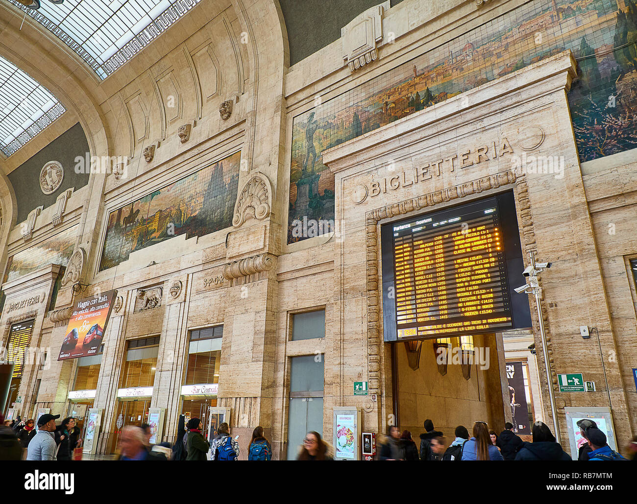 Travellers in the main hall, antique Sala della Biglietteria, of the Milano Centrale train station. Milan, Lombardy, Italy. Stock Photo