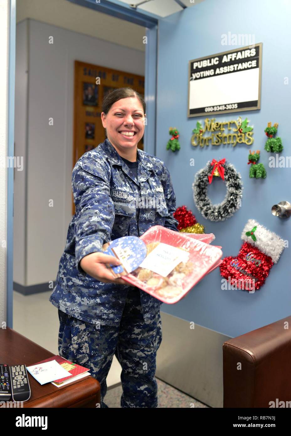 MISAWA, Japan (Dec. 7, 2016) Petty Officer 2nd Class Raven Harding hands out packages of cookies for the 2016 Cookie Caper at Misawa Airbase. Hundreds of volunteers made over 36,000 cookies and packaged them into 3,000 gifts to give to single unaccompanied Servicemembers stationed at Misawa Airbase for the holidays. Stock Photo
