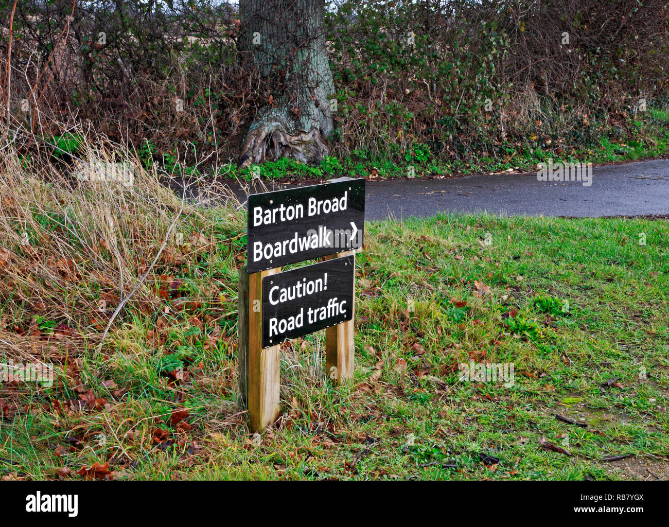 A sign to Barton Broad Boardwalk at the exit of a footpath to a country road in the Norfolk Broads at Neatishead, Norfolk, England, UK, Europe. Stock Photo