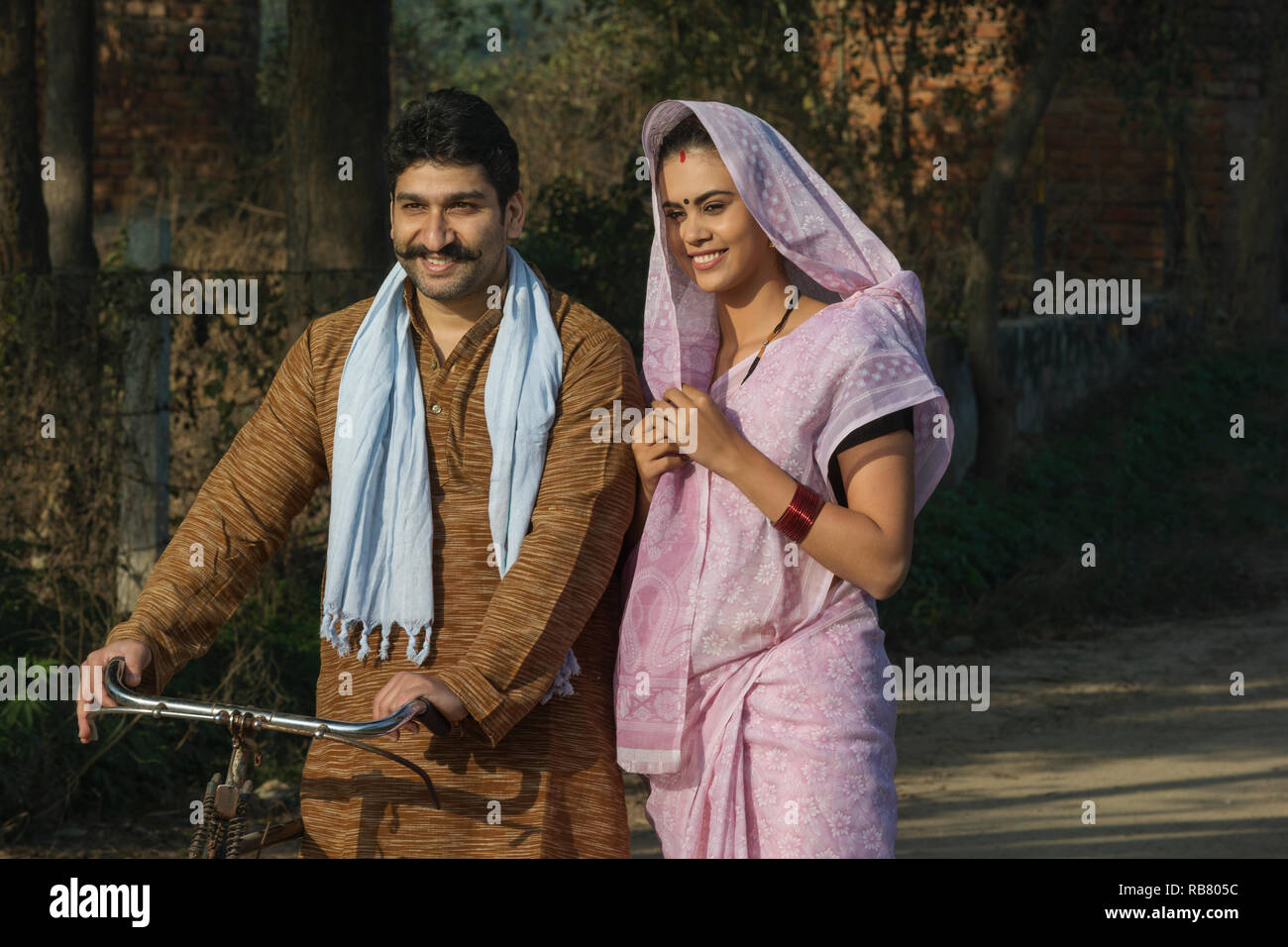 Portrait of a happy rural couple walking on a street in village Stock ...
