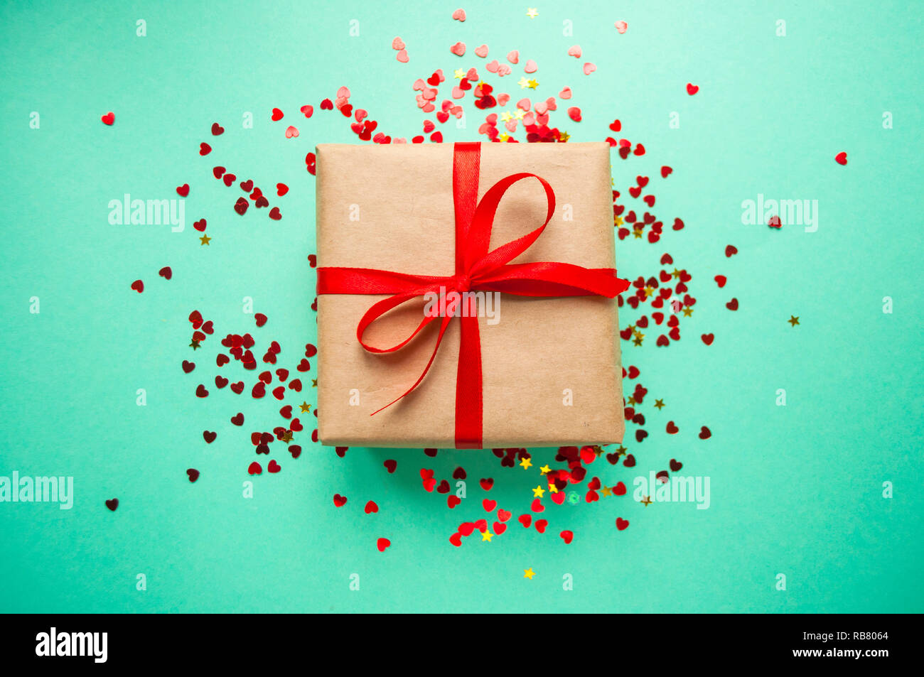 Gift box tied with red ribbon on pastel pink background Stock Photo - Alamy