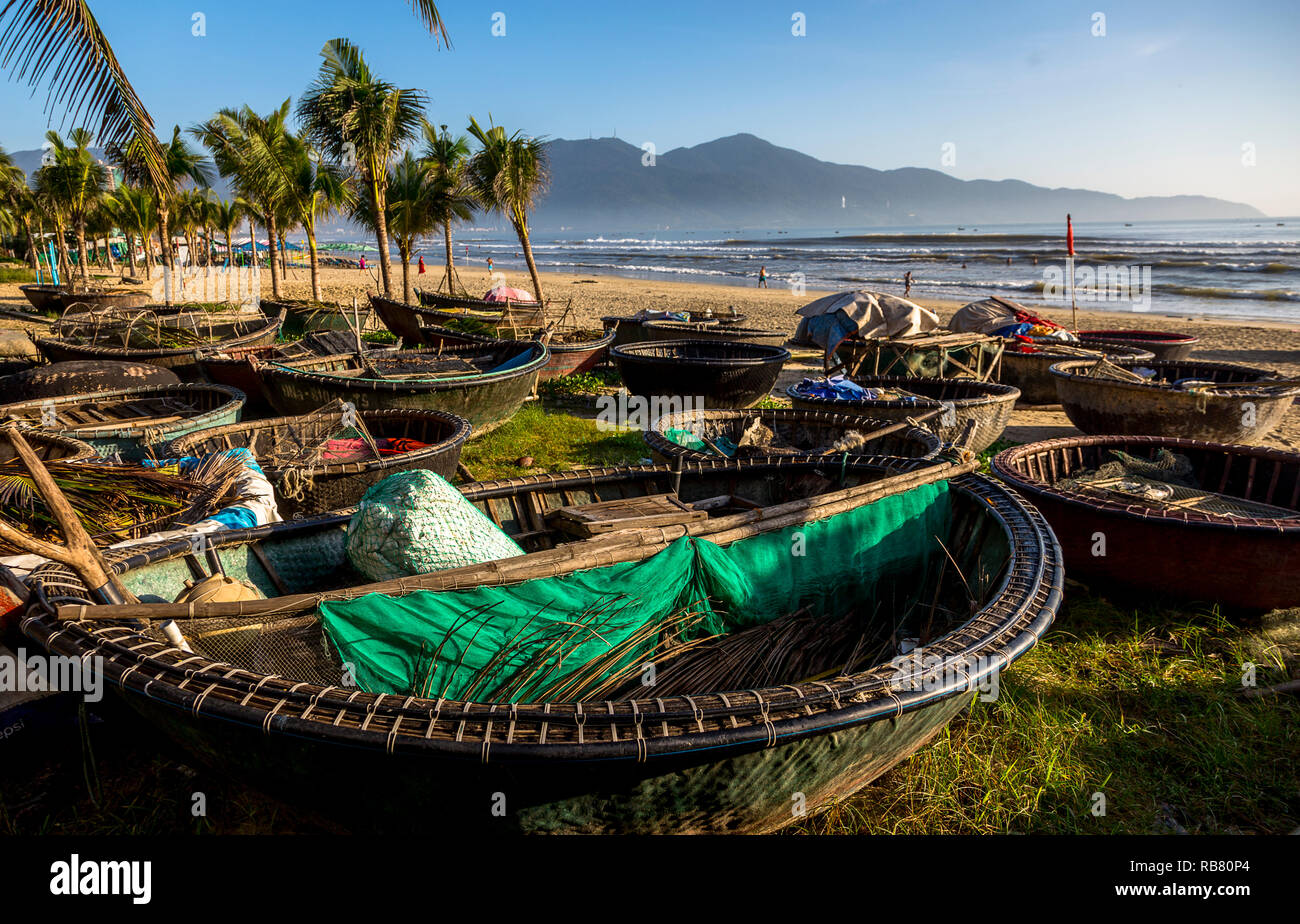 Group of Vietnam round fishing boats in the sand beach full of nets awaiting use by the fishermen. My Khe Beach Stock Photo