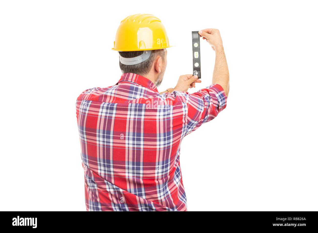 Builder man with back to camera checking vertical surface with bubble level isolated on white background Stock Photo
